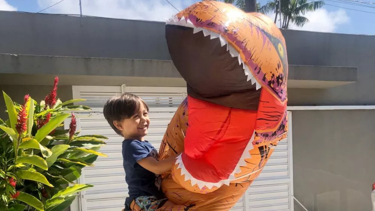 Médico se fantasia de dinossauro para abraçar filho que não via há um mês