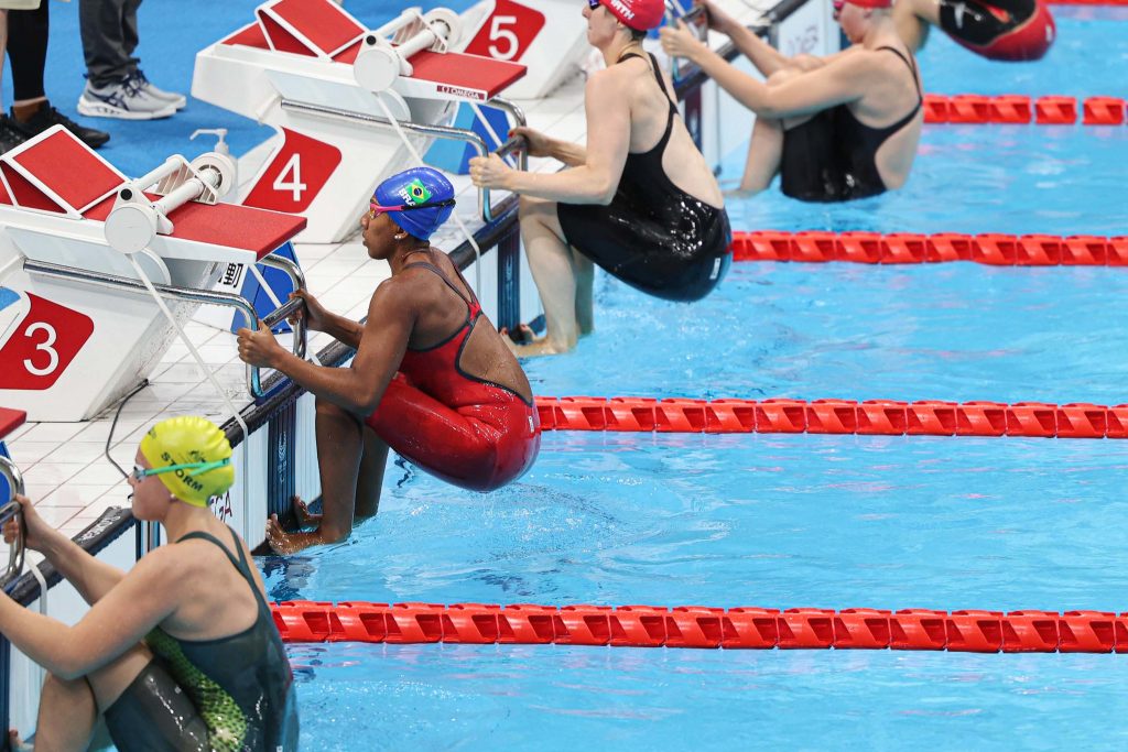 Foto mostra as quatro nadadoras se preparando para o salto de costas em piscina paralímpica. Ana é a única negra dentre elas.