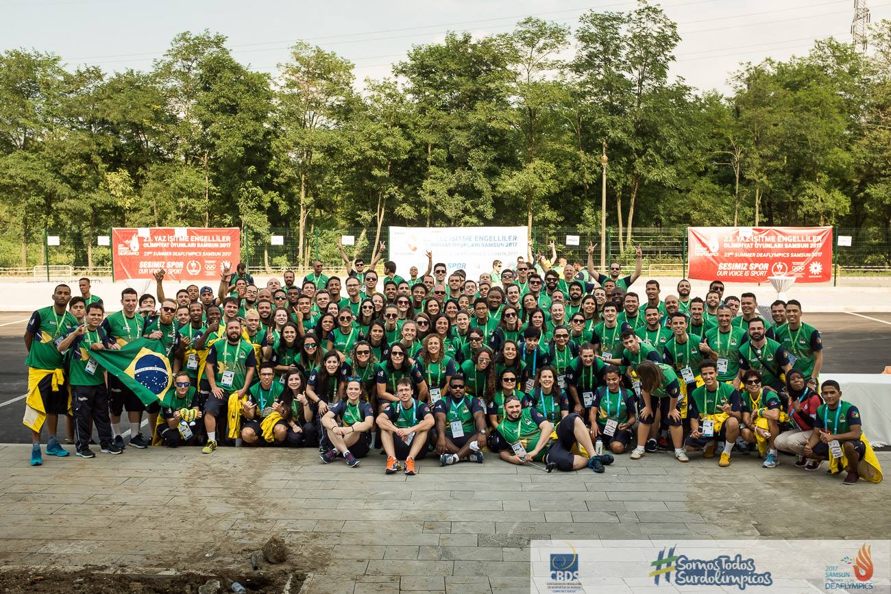 Foto oficial da delegação brasileira de surdoatletas, mais de 50 pessoas, com roupas verde e amarelo.