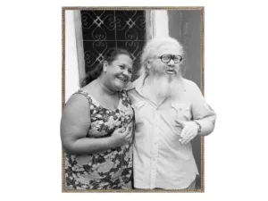 Imagem de um casal abraçado em frente a um portão.